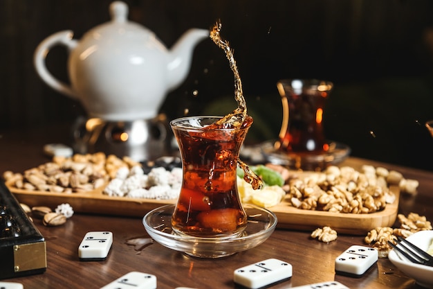 Black tea in armudu glass with various sweets on the table close up view