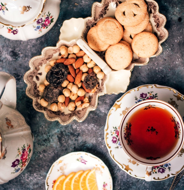 Free photo black tea with nuts and cookies