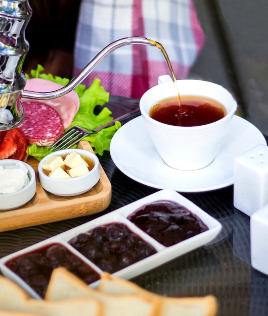 Free photo black tea with various jam and side sausages