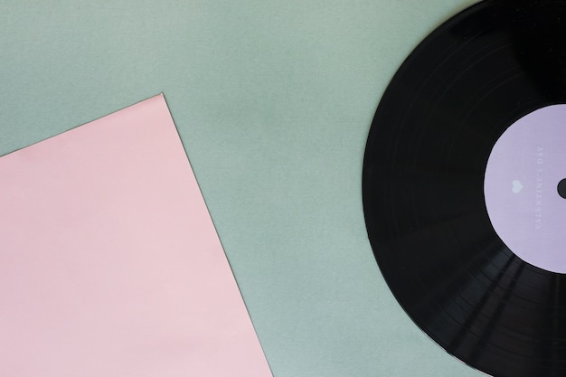 Free photo black vinyl record with paper on table