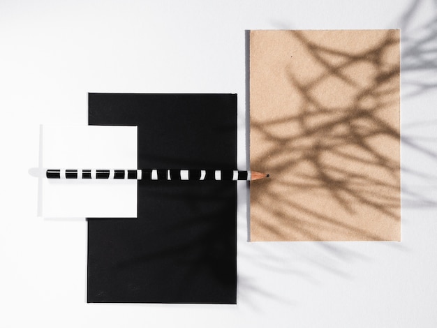 Black and white blankets with a striped pencil and a beige blanket with a branch shadow