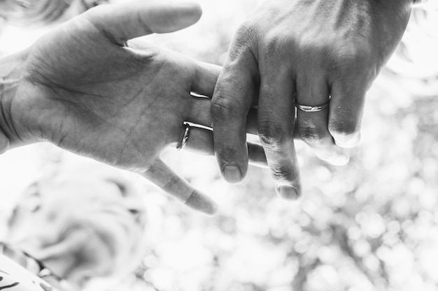 Free photo black and white picture of newlyweds' hands holding each other tender