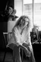 Free photo black and white portrait of beautiful woman posing indoors on a chair