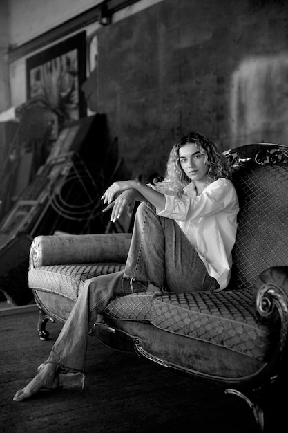 Black and white portrait of beautiful woman posing indoors on a couch