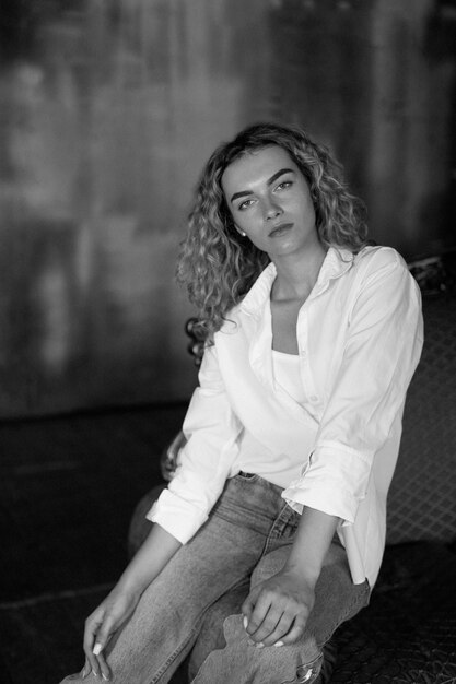 Black and white portrait of beautiful woman posing indoors on a couch