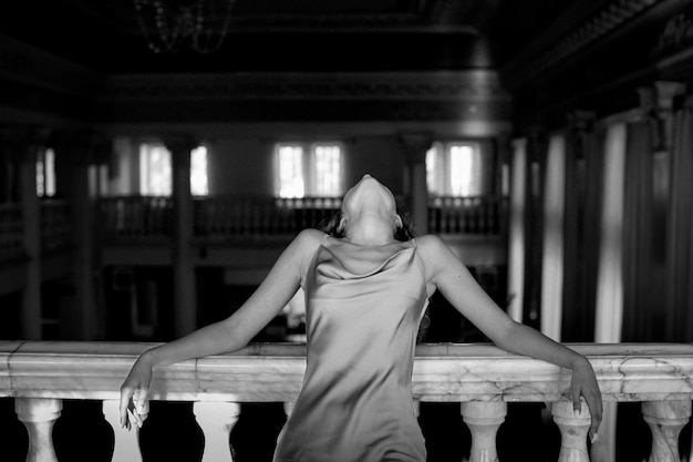 Black and white portrait of beautiful woman posing indoors in a dress