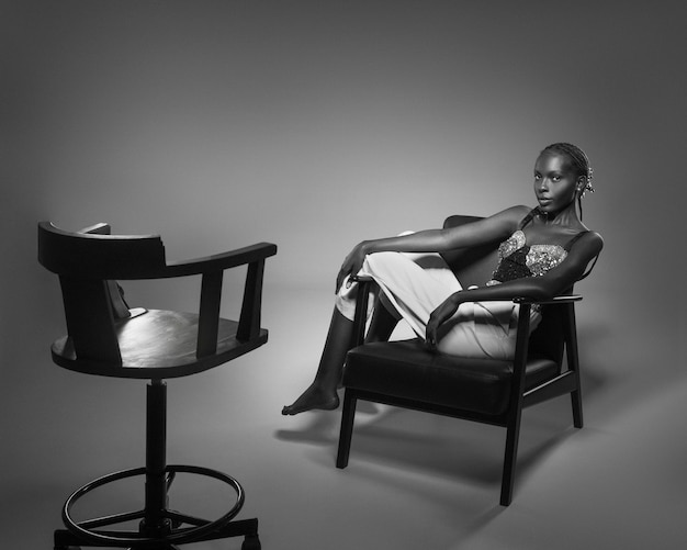 Free photo black and white portrait of woman on chair in old hollywood glamour style