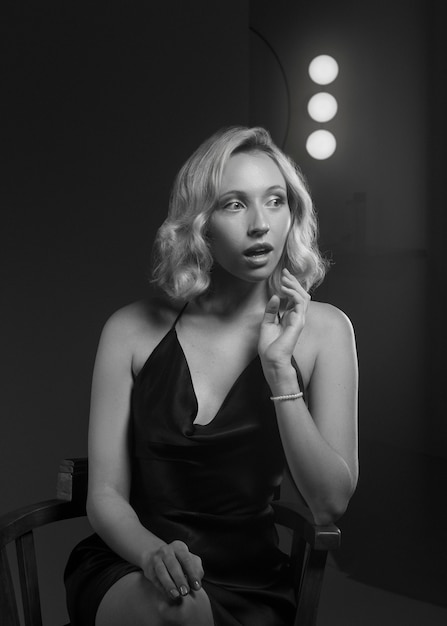 Black and white portrait of woman on chair in old hollywood glamour style