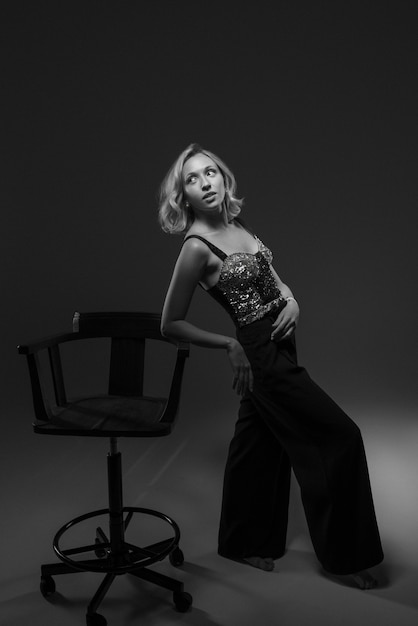 Free Photo black and white portrait of woman on chair in old hollywood glamour style