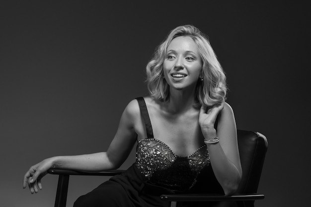 Black and white portrait of woman on chair in old hollywood glamour style