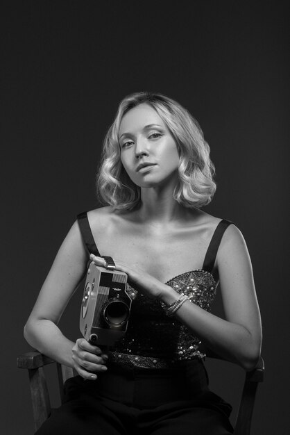 Black and white portrait of woman with camera in old hollywood glamour style