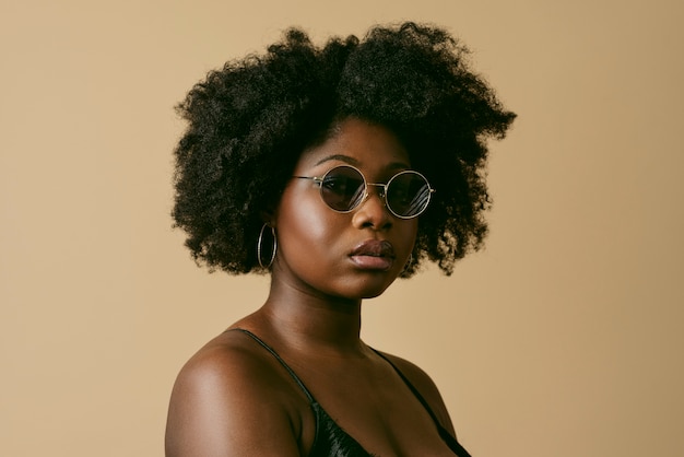 Free photo black woman posing with sunglasses side view