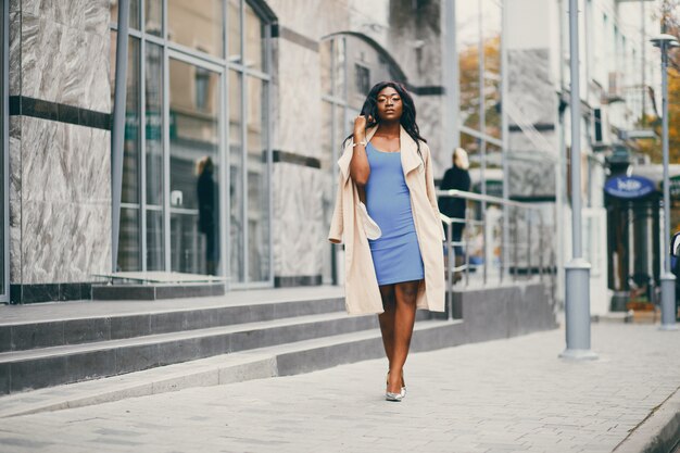 Black woman standing in a autumn city