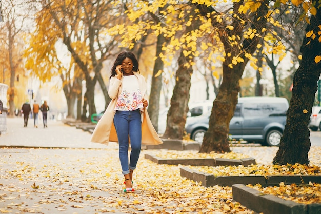 Black woman standing in a autumn city