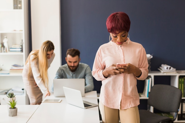 Black woman using smartphone in office