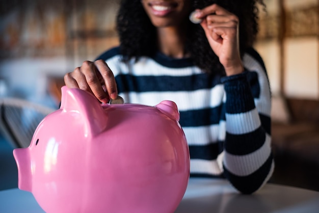 Black woman with saving piggy bank