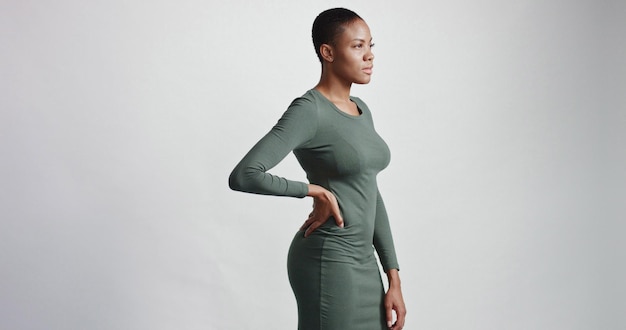 Black woman with a short haircut in studio shootsmiling and wearing dress