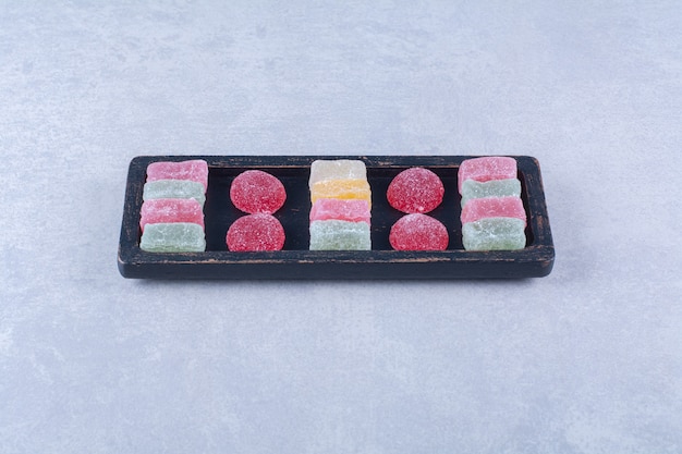 A black wooden board full of sugary colorful candies