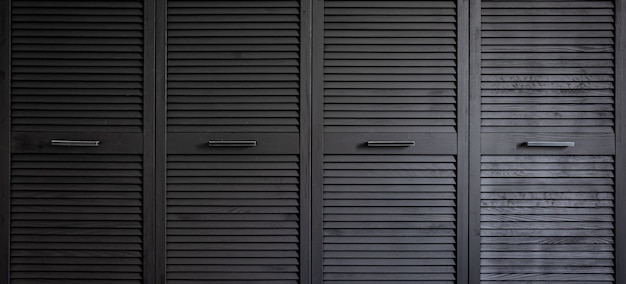 Free photo black wooden wardrobe decorated with blinds, wardrobe with blinds decoration.