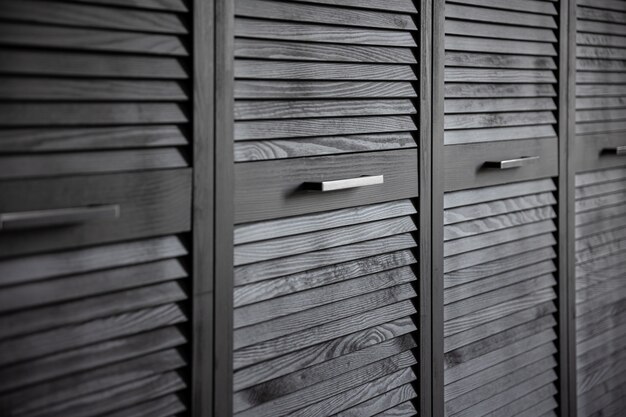 Black wooden wardrobe decorated with blinds, wardrobe with blinds decoration.