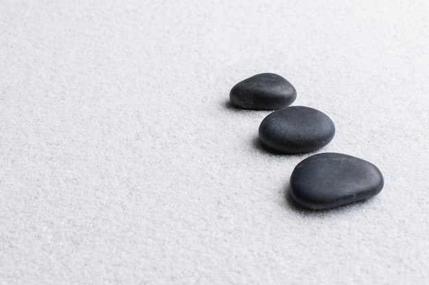 Free photo black zen stones stacked on white background in wellness concept