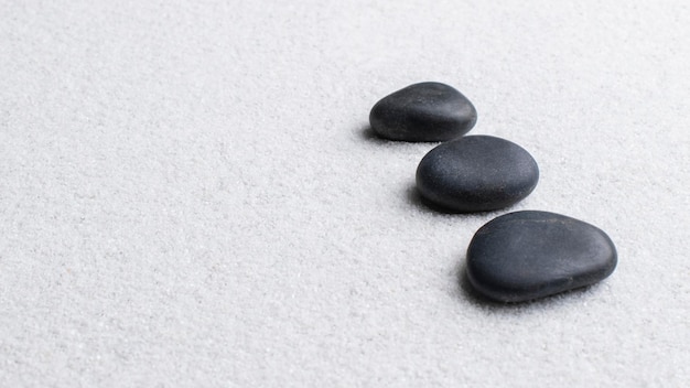 Black zen stones stacked on white background in wellness concept