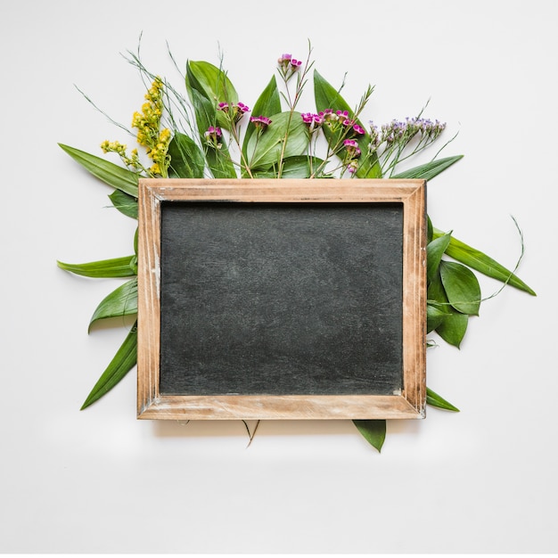 Free photo blackboard on leaves and flowers