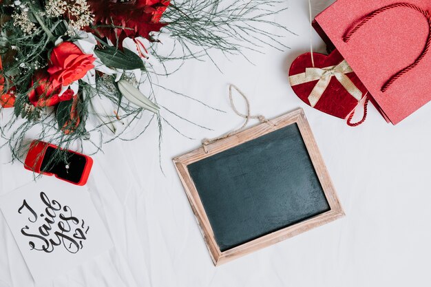 Blackboard near engagement ring and presents