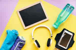 Free photo blackboard near smartphone and bottle with towels