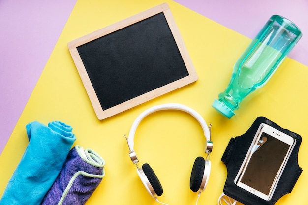 Blackboard near smartphone and bottle with towels