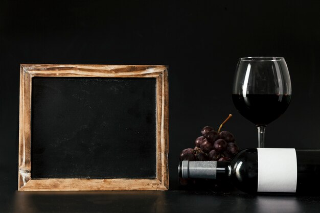 Blackboard near wine and grape