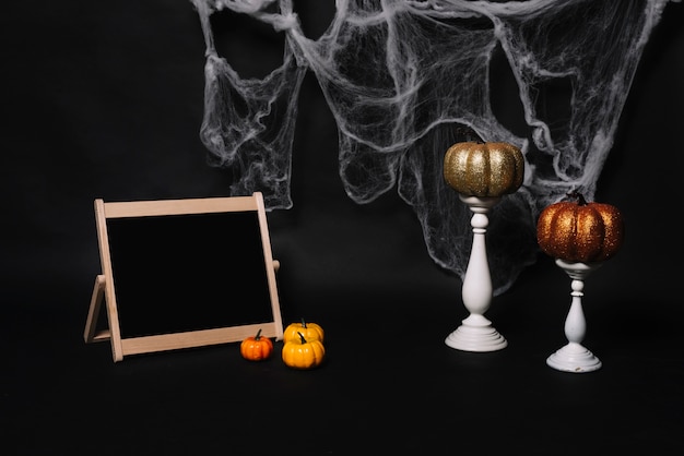 Free Photo blackboard and pumpkins near candles and web