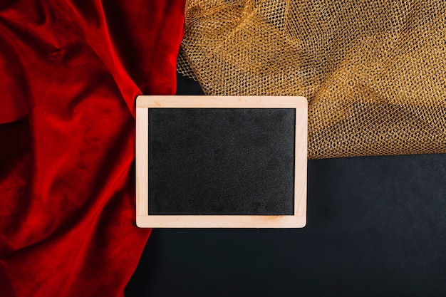 Free Photo blackboard on red and golden fabrics