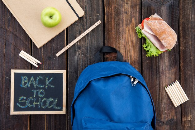 Blackboard, sandwich and school supplies