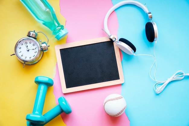 Blackboard and sports equipment on paper background