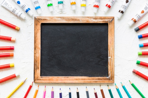 Free photo blackboard surrounded by painting material