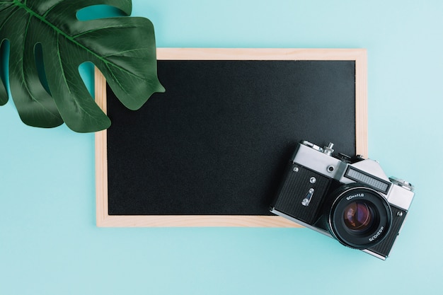 Free photo blackboard with camera and leaf