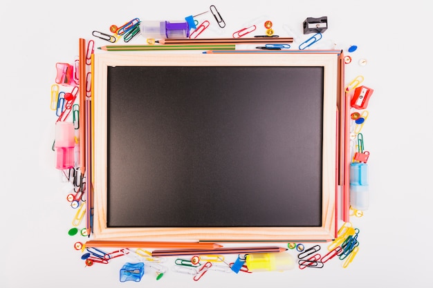 Blackboard with different school stationery