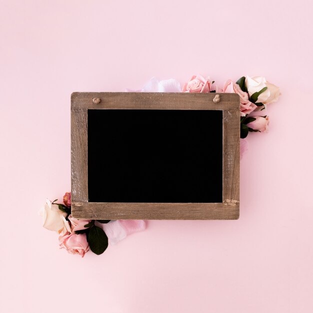 Blackboard with pink roses on pink background