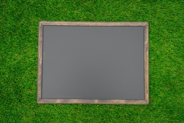 Free Photo blank black board on grass field