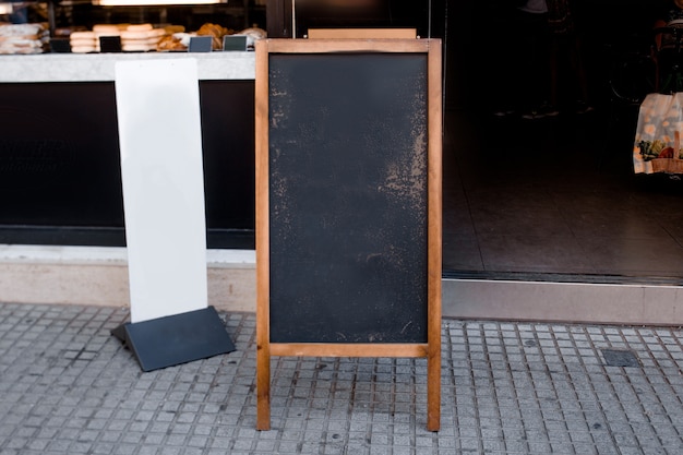 Blank blackboard menu and white billboard in front of the restaurant at street