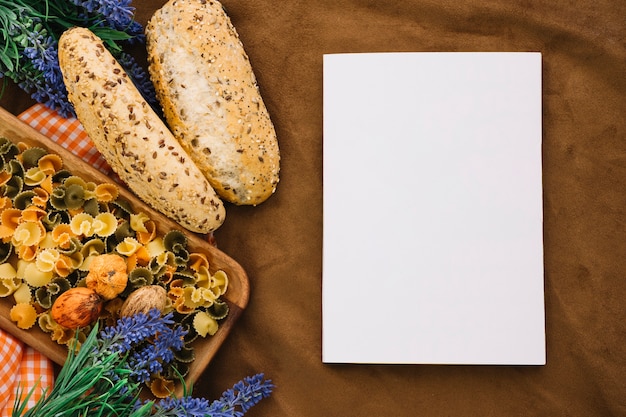 Free Photo blank book mockup with bread and pasta