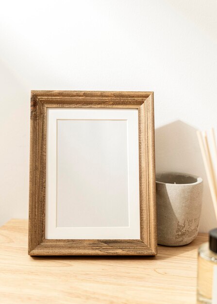 Blank decorative picture frame on wooden table