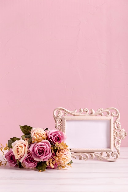 Blank frame and beautiful rose bouquet