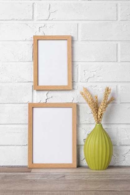 Blank frame collection on wall and next to vase