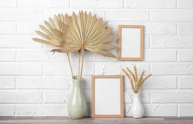 Free Photo blank frame collection on wall and next to vase