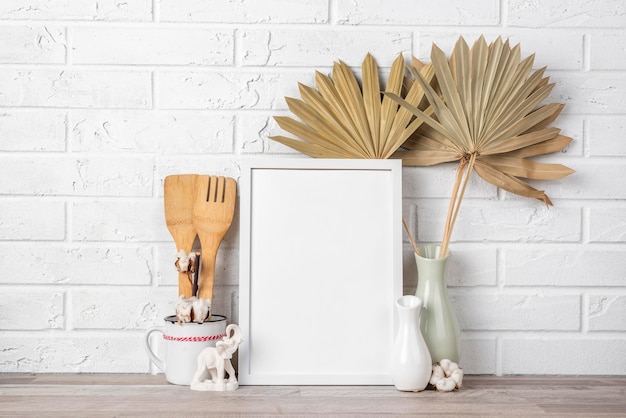 Blank frame on shelf beside vase