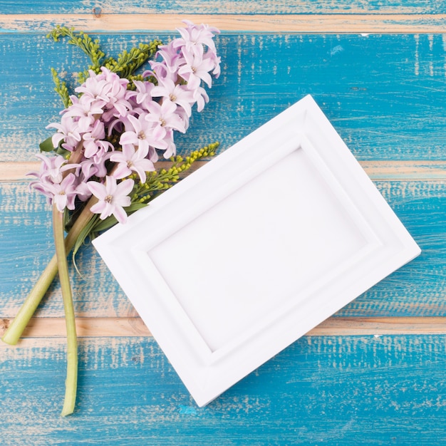 Free Photo blank frame with flowers on table