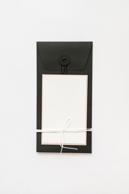 Blank greeting card tied with white string against white background