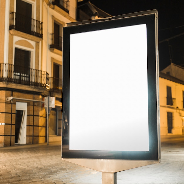 Blank illuminated vertical billboard at night